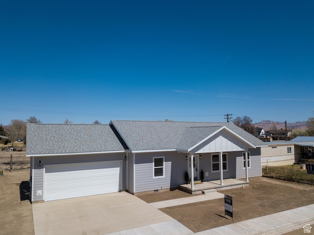 view of front of home with covered porch, a garage, board and batten siding, concrete driveway, and roof with shingles