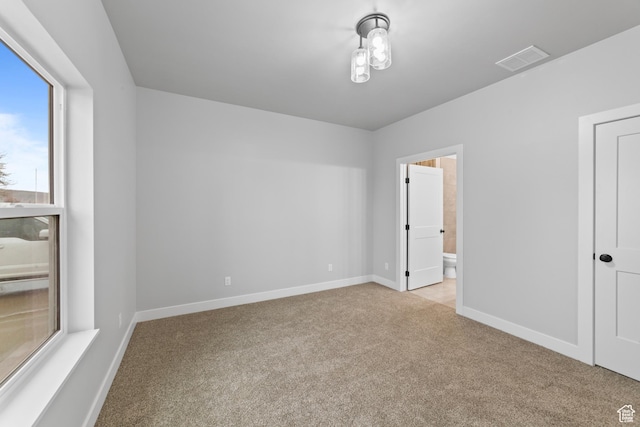 245 E Tidwell Ave Unit 5, Green River, UT 84525 - unfurnished bedroom featuring carpet floors, baseboards, connected bathroom, and visible vents
