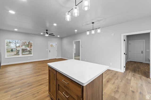 245 E Tidwell Ave Unit 5, Green River, UT 84525 - kitchen featuring light wood-style flooring, light countertops, a center island, and decorative light fixtures