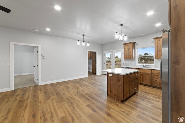 245 E Tidwell Ave Unit 5, Green River, UT 84525 - kitchen with a sink, open floor plan, light countertops, light wood-style flooring, and a kitchen island