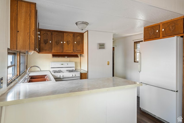 102 N 3910 W, Hurricane, UT 84737 - kitchen with a sink, a peninsula, brown cabinets, under cabinet range hood, and white appliances