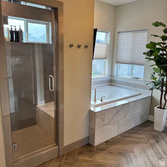 bathroom with baseboards, a garden tub, and a shower stall
