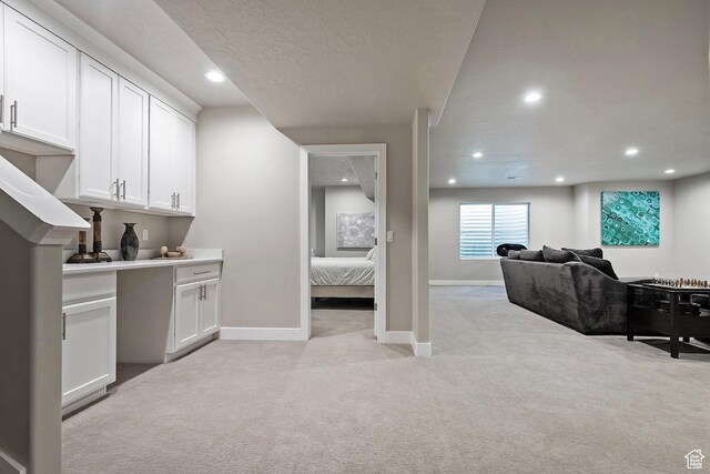 interior space featuring light carpet, baseboards, recessed lighting, and a textured ceiling