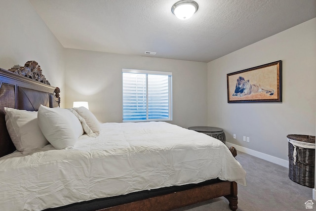 carpeted bedroom featuring baseboards, a textured ceiling, and visible vents