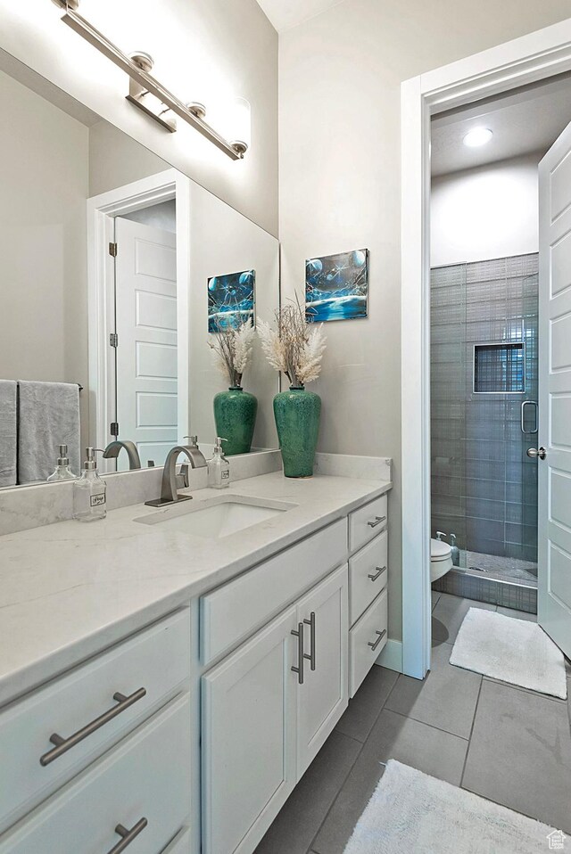 full bath featuring toilet, vanity, tile patterned flooring, and a shower stall