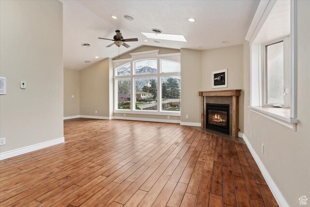 7342 S Promenade Cir E, Cottonwood Heights, UT 84121 - unfurnished living room with baseboards, visible vents, wood finished floors, and a glass covered fireplace