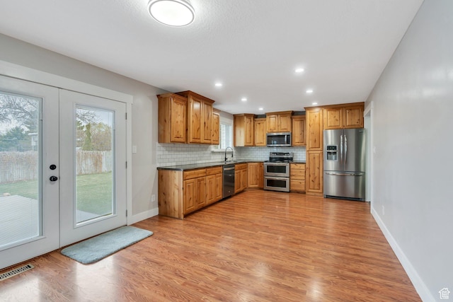 975 N 200 E, Lehi, UT 84043 - kitchen featuring backsplash, a sink, light wood-style floors, visible vents, and appliances with stainless steel finishes
