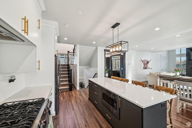 52 N 400 W, Farmington, UT 84025 - kitchen with a center island, light countertops, appliances with stainless steel finishes, a kitchen breakfast bar, and white cabinetry