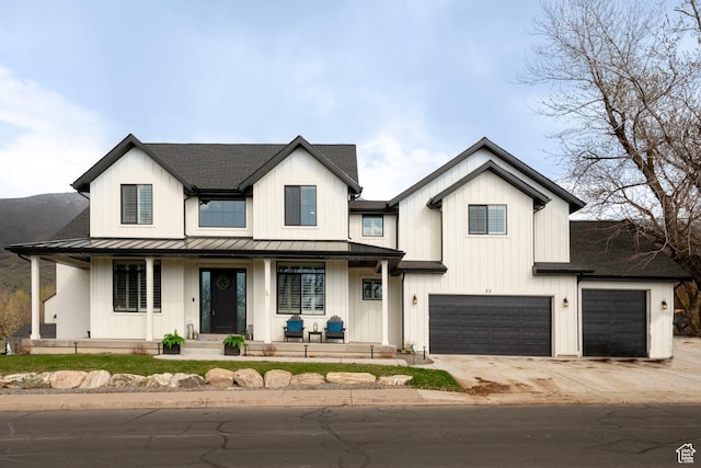 modern farmhouse featuring driveway, a standing seam roof, a garage, metal roof, and a porch