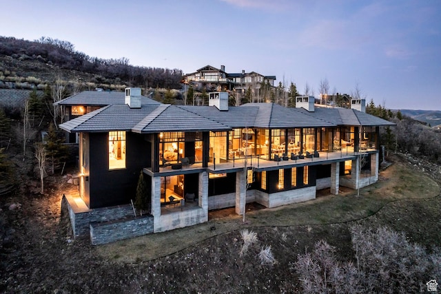 8006 N Sunrise Loop, Park City, UT 84098 - back of property at dusk with a chimney and a tiled roof