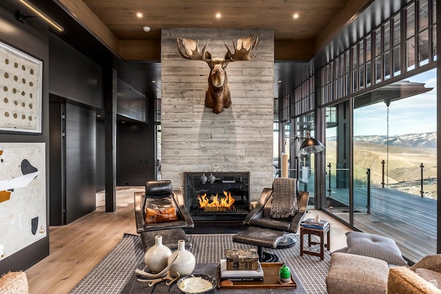 8006 N Sunrise Loop, Park City, UT 84098 - living room featuring a high ceiling, wood ceiling, a mountain view, a stone fireplace, and wood finished floors