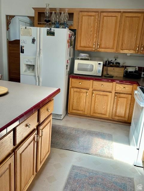 kitchen featuring tile counters and white appliances