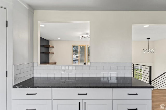 kitchen featuring recessed lighting, white cabinets, backsplash, and dark stone counters