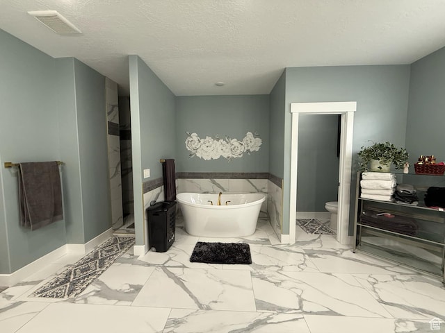 1240 W 2360 N, Helper, UT 84526 - bathroom featuring a freestanding tub, toilet, a textured ceiling, marble finish floor, and visible vents