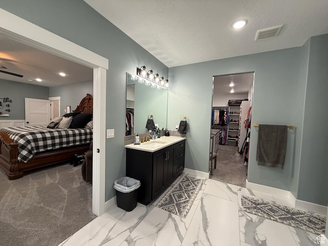 1240 W 2360 N, Helper, UT 84526 - full bathroom featuring vanity, a walk in closet, baseboards, a textured ceiling, and visible vents