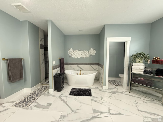 1240 W 2360 N, Helper, UT 84526 - full bathroom with a textured ceiling, visible vents, marble finish floor, toilet, and a freestanding tub