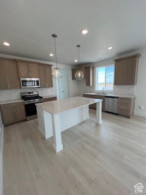 3199 N 3500 W Unit 379, Plain City, UT 84404 - kitchen featuring appliances with stainless steel finishes, recessed lighting, light wood-style flooring, backsplash, and light countertops