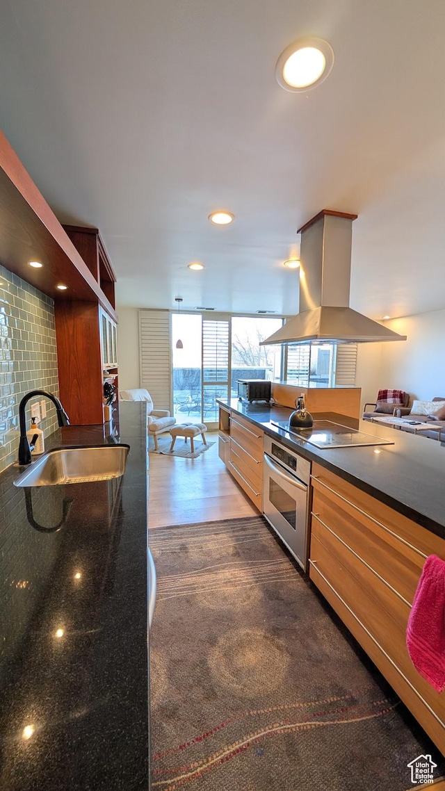 777 E S Temple Unit 3J, Salt Lake City, UT 84102 - kitchen featuring island exhaust hood, black microwave, dark countertops, a sink, and stainless steel oven