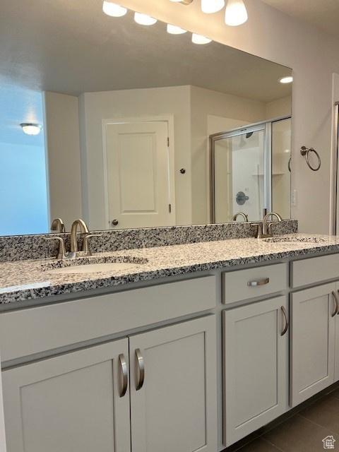 6850 S Static Peak Dr Unit 261, West Jordan, UT 84081 - bathroom with tile patterned floors, double vanity, a shower stall, and a sink