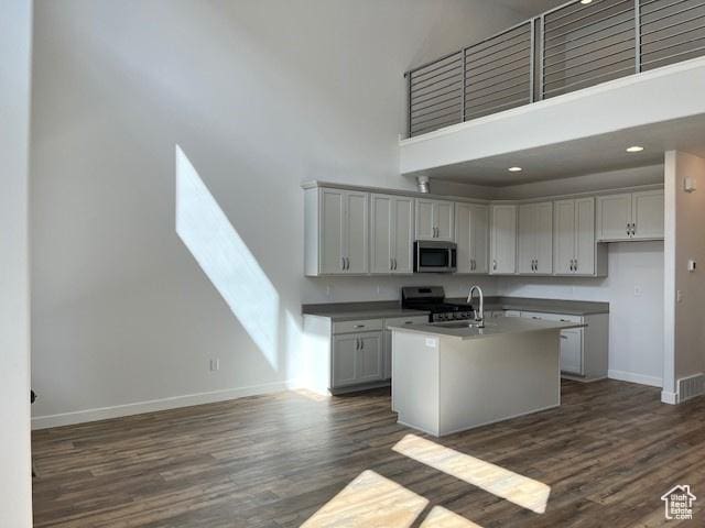 6850 S Static Peak Dr Unit 261, West Jordan, UT 84081 - kitchen with a towering ceiling, dark wood finished floors, baseboards, and appliances with stainless steel finishes