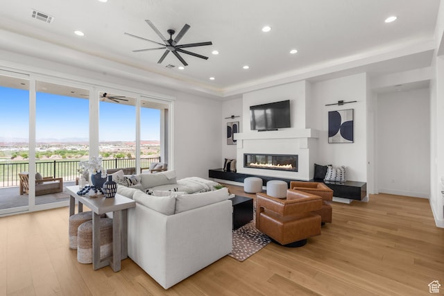 1248 S Seminole Way, Washington, UT 84780 - living room featuring a glass covered fireplace, light wood finished floors, ceiling fan, a raised ceiling, and recessed lighting