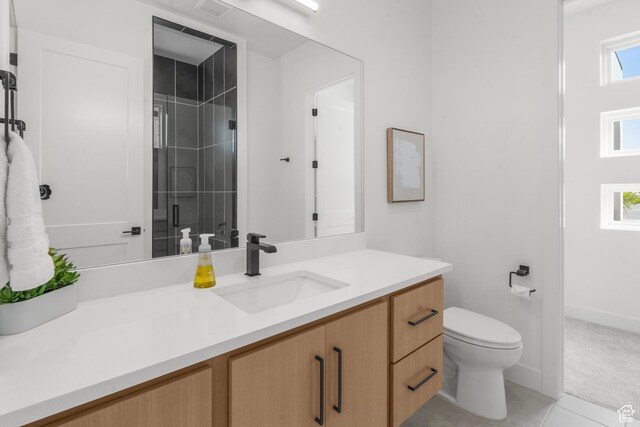 1248 S Seminole Way, Washington, UT 84780 - bathroom featuring vanity, toilet, a tile shower, tile patterned flooring, and baseboards