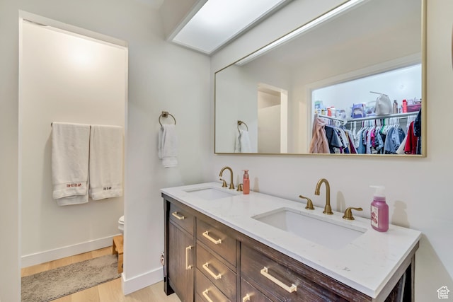 5518 S 875 E, South Ogden, UT 84405 - bathroom with double vanity, a sink, toilet, and wood finished floors