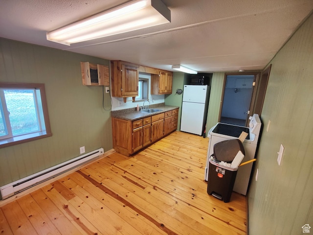 124 N Lakeview Dr, Manila, UT 84046 - kitchen featuring brown cabinets, a sink, baseboard heating, light wood-style flooring, and freestanding refrigerator