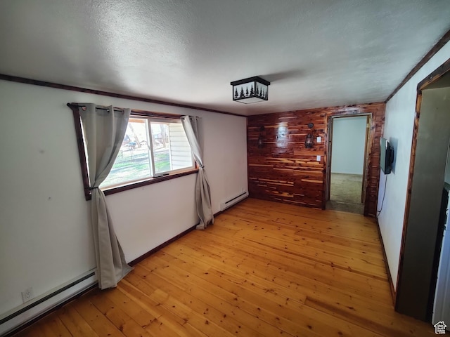 124 N Lakeview Dr, Manila, UT 84046 - unfurnished room featuring a textured ceiling, wood walls, baseboard heating, and light wood finished floors