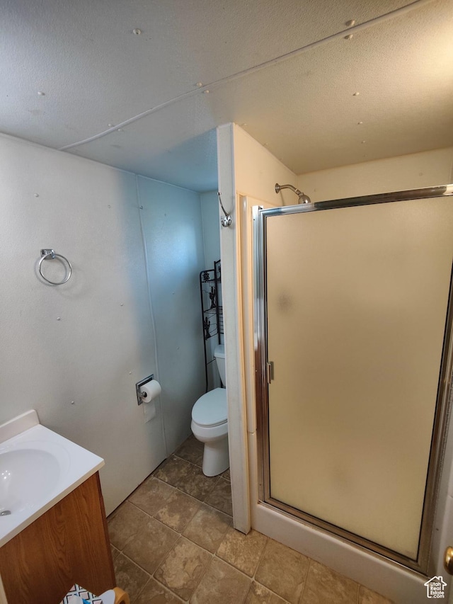 124 N Lakeview Dr, Manila, UT 84046 - bathroom featuring toilet, a textured ceiling, a shower stall, and vanity