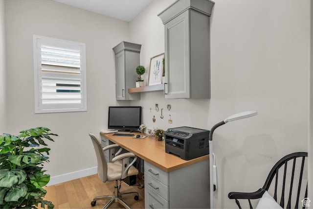 office space featuring baseboards and light wood-type flooring