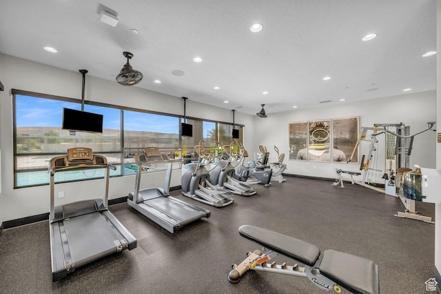 gym featuring recessed lighting, baseboards, and a textured ceiling