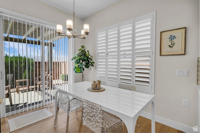 dining room with an inviting chandelier, baseboards, and wood finished floors