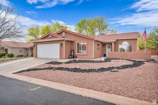 view of front of property with driveway, stucco siding, a tiled roof, and a garage