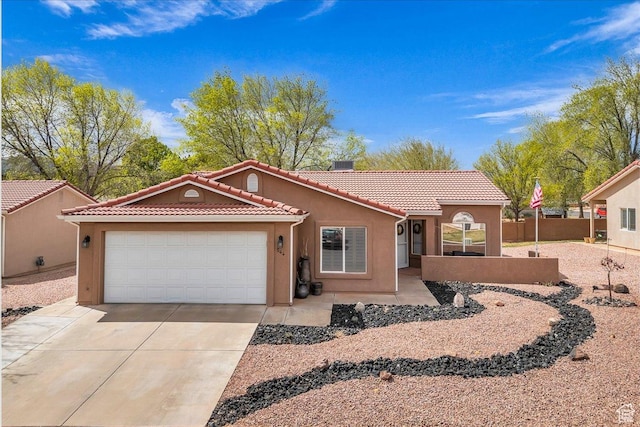 544 S Fiesta Dr, Ivins, UT 84738 - view of front of house with a tile roof, stucco siding, fence, an attached garage, and driveway