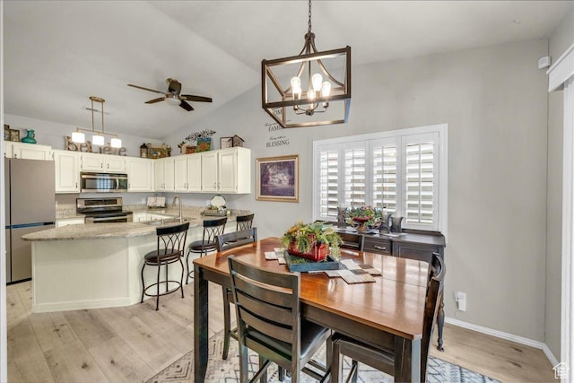 544 S Fiesta Dr, Ivins, UT 84738 - dining room featuring light wood-style flooring, ceiling fan with notable chandelier, baseboards, and vaulted ceiling