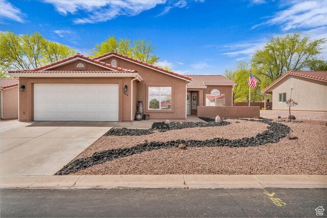544 S Fiesta Dr, Ivins, UT 84738 - view of front of home featuring stucco siding, an attached garage, a tiled roof, and concrete driveway
