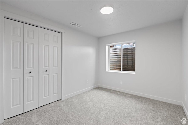 4489 W Black Elk Way, West Jordan, UT 84088 - unfurnished bedroom with light carpet, baseboards, visible vents, and a closet