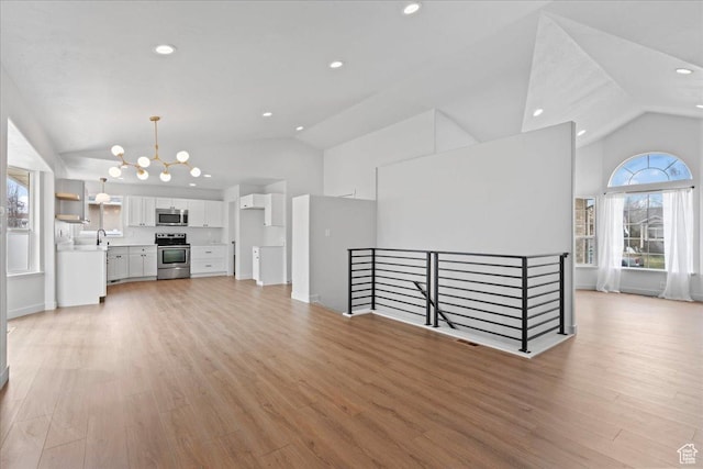 4489 W Black Elk Way, West Jordan, UT 84088 - unfurnished living room featuring a notable chandelier, recessed lighting, light wood-style flooring, and a sink