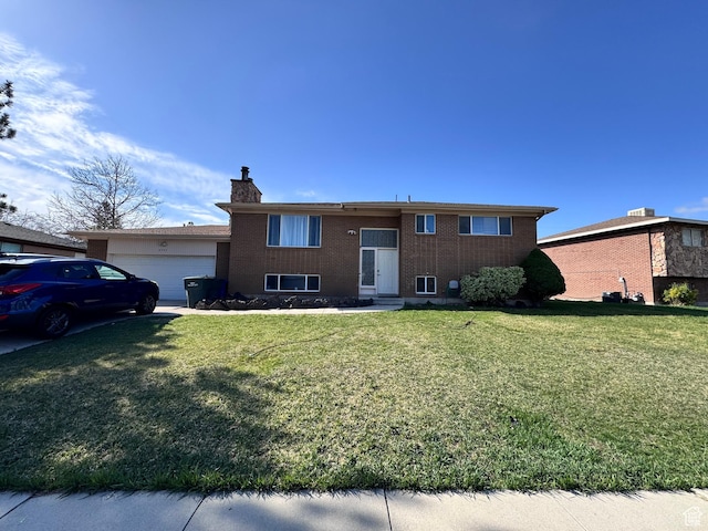 bi-level home featuring a front yard, a garage, and a chimney
