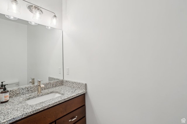 half bathroom with vanity and toilet