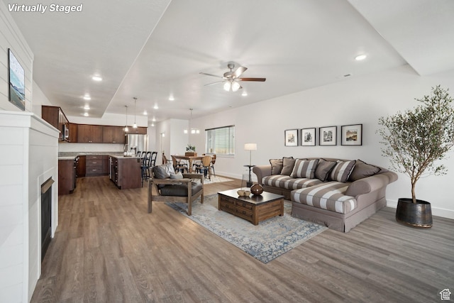 living room with ceiling fan, recessed lighting, wood finished floors, and baseboards