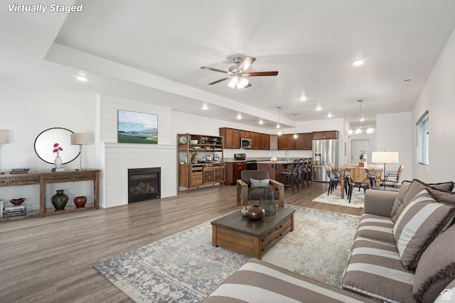 living room featuring light wood-style floors, a fireplace, a ceiling fan, and recessed lighting