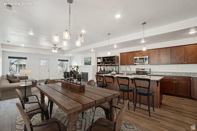 dining room featuring a raised ceiling, ceiling fan, recessed lighting, and dark wood-style flooring