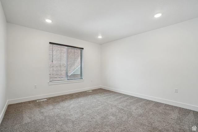 empty room with baseboards, recessed lighting, and carpet