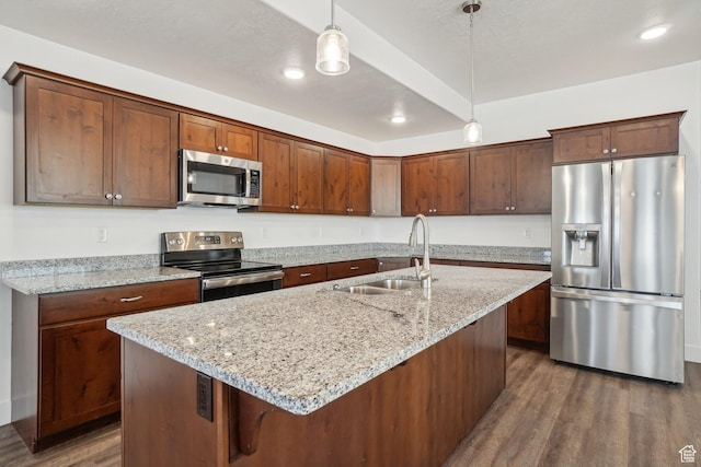 kitchen featuring decorative light fixtures, a sink, dark wood finished floors, light stone countertops, and stainless steel appliances
