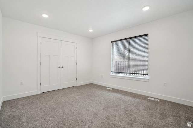 unfurnished bedroom featuring baseboards, carpet, visible vents, and recessed lighting