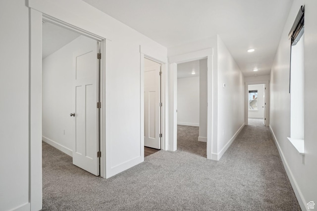 hallway featuring recessed lighting, carpet, and baseboards