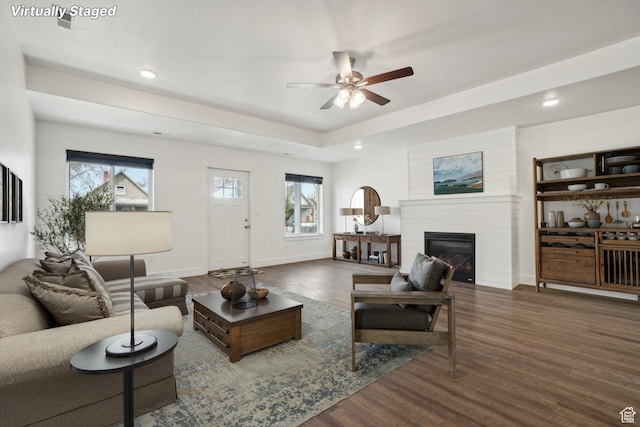 living area featuring baseboards, a ceiling fan, a fireplace, recessed lighting, and wood finished floors