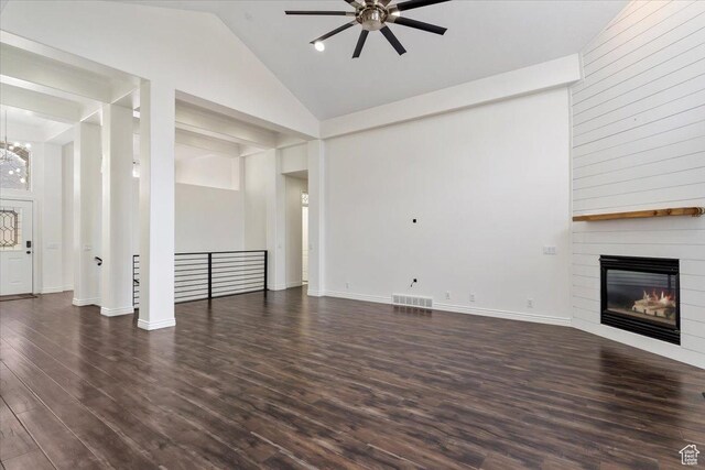 unfurnished living room with high vaulted ceiling, a large fireplace, visible vents, wood finished floors, and ceiling fan with notable chandelier